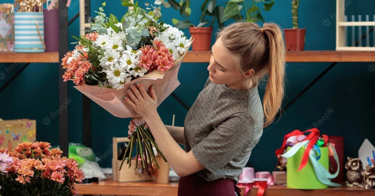 Woman shop owner holding flowers